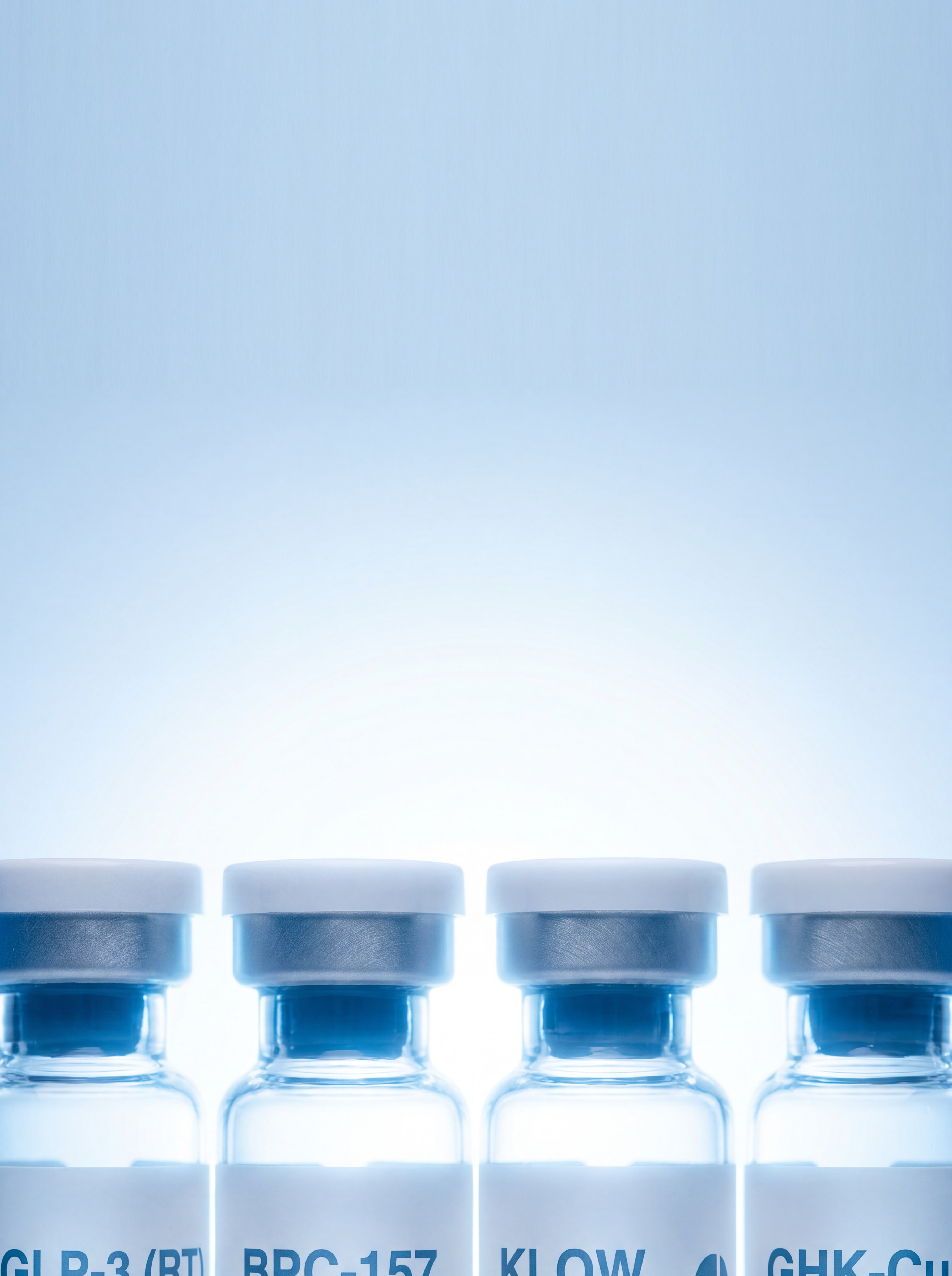 glp-3, bpc-157, klow and ghk-cu research vials in a backlit row